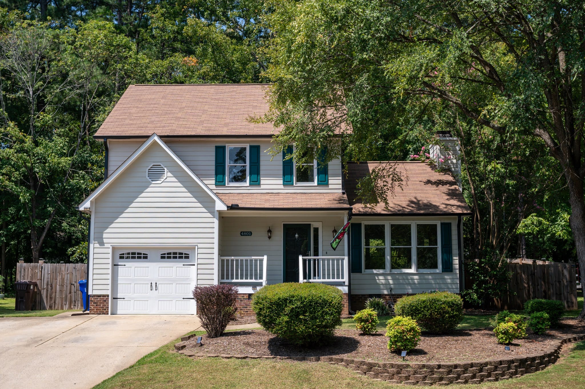 A colonial style white exterior home with clay roof tile and free in front yard