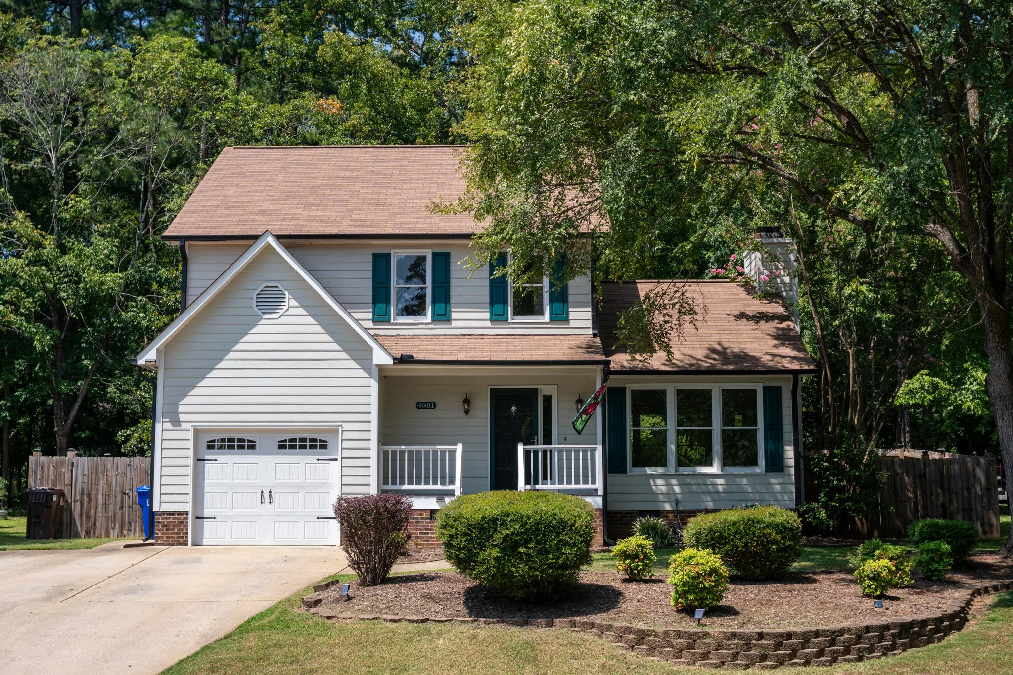 A colonial style white exterior home with clay roof tile and free in front yard