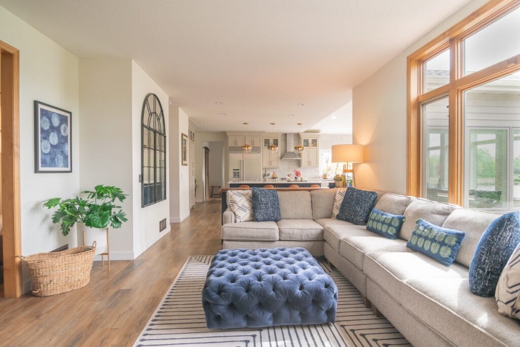 Living room with kitchen in the background and arch mirror handing on the wall.