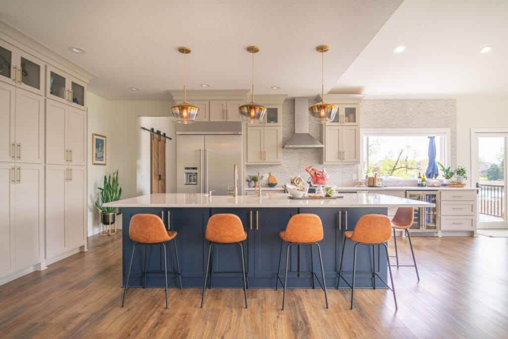 four leather back chairs with blue cabinets and large white quartz counter top in kitchen.