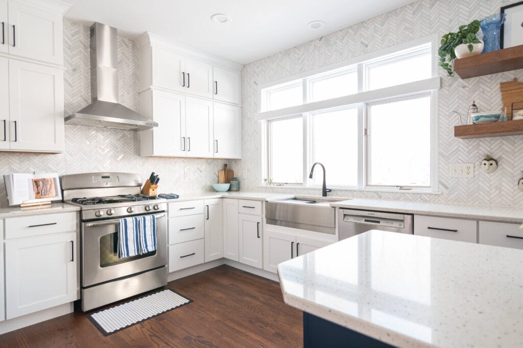 Kitchen with white cabinets and stainless steel oven and hood range.
