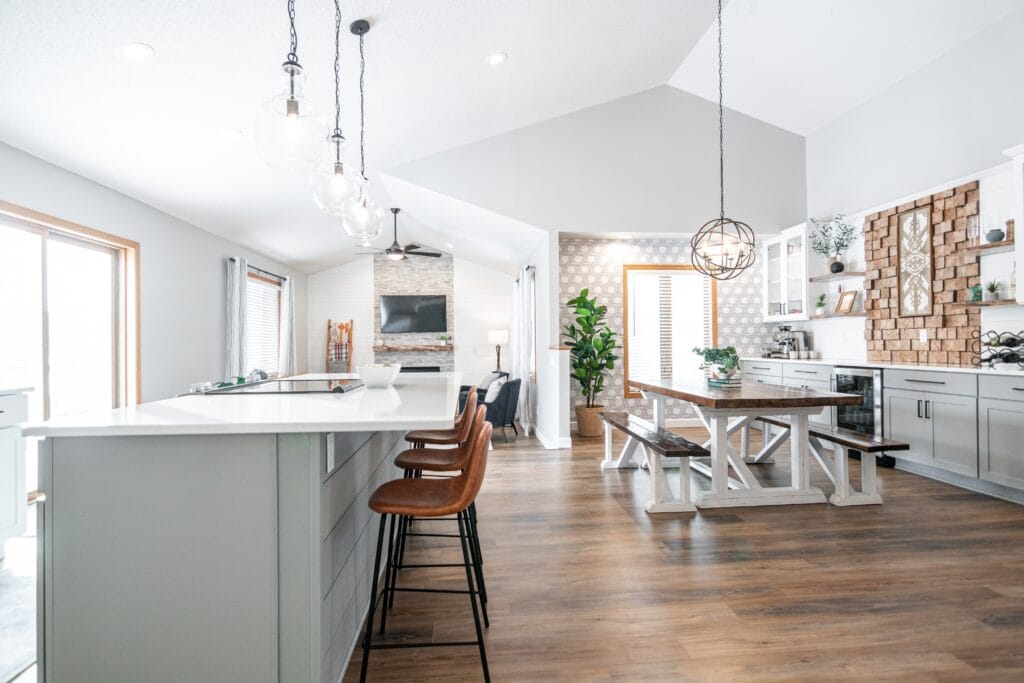 Bright kitchen, dinning room, and living room with a farmhouse style dinning table.
