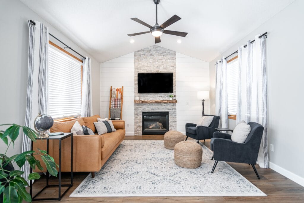 Living room with ceiling fan and leather couch and fireplace