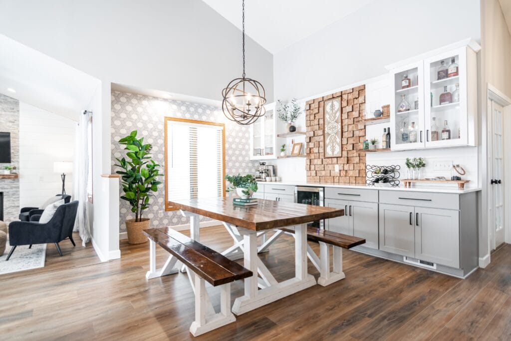 Farmhouse style dinning table with bench seating and custom light fixture with cut wood framed picture frame.